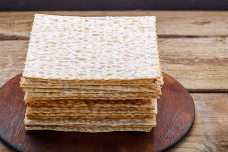 Matzo stack on a round stand on a wooden table. Horizontal photoの写真素材
