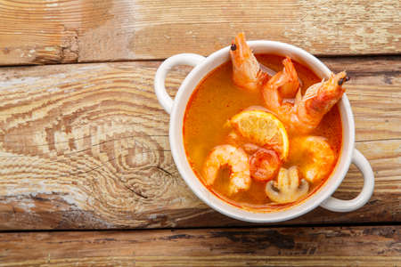 Tom yum soup with shrimps and coconut milk in a tureen.Copy place.の写真素材