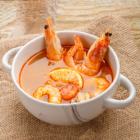 Tom yam soup with shrimps and coconut milk in a tureen.の写真素材