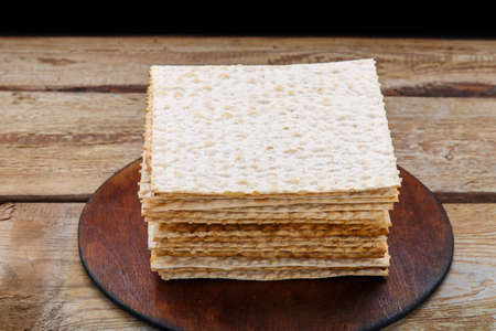 Matzo stack on a round stand on a wooden table.の写真素材