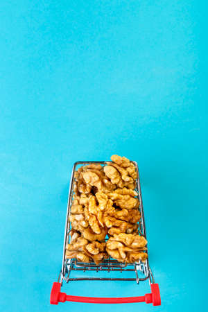 Food cart filled with peeled walnuts on a blue background. Copy space.の写真素材