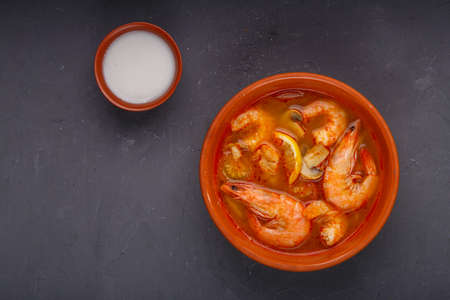 Tom yam soup with shrimps in a plate on a concrete background.の写真素材