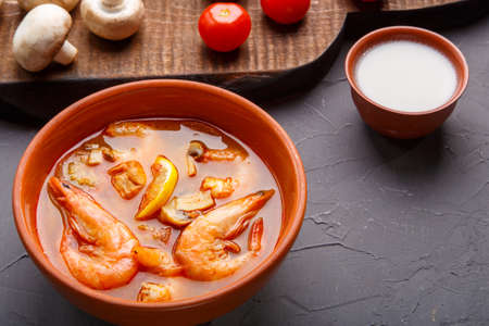 Tom yam soup with shrimps in a plate on a concrete background.の写真素材