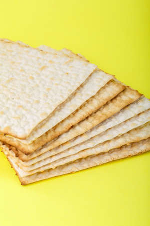 Fragment of matzo several sheets one on top of the other on a yellow background.の写真素材
