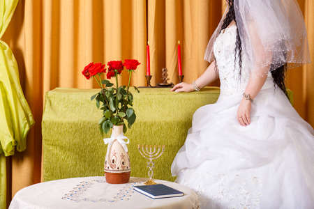 A faceless Jewish bride in a lush white dress, her face covered with a veil, crying before the chuppah ceremony does not want to get married.の写真素材