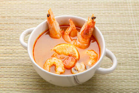 Tom yam soup with shrimps and coconut milk in a tureen.の写真素材