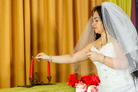 Before the chuppah ceremony, a Jewish bride lights candles.の写真素材