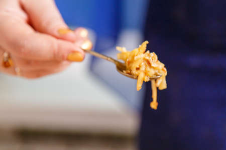 Haroset of apples and nuts for seder pesach in a spoon in a womans hand.