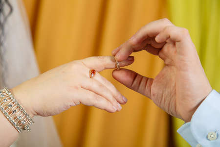 The groom putting the bride on the index finger on the Jewish wedding hand close-up.の写真素材