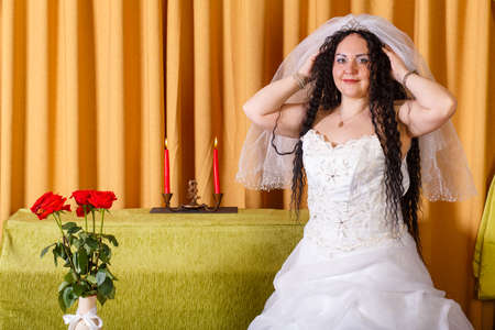 A Jewish bride in a white wedding dress wears a veil before the chuppah ceremony. Horizontal photoの写真素材
