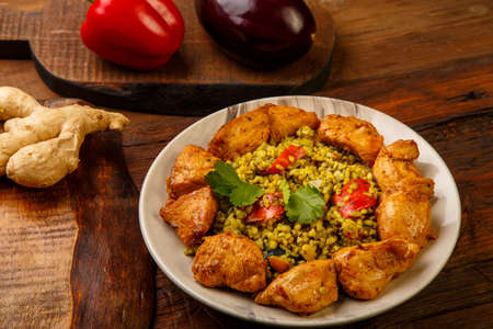 Food for suhoor in Ramadan bulgur post with beef in a plate on a wooden table next to vegetables on a board. Horizontal photoの写真素材