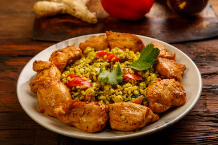 Food for suhoor in Ramadan bulgur post with beef in a plate on a wooden table next to vegetables on a board. horizontal photoの写真素材