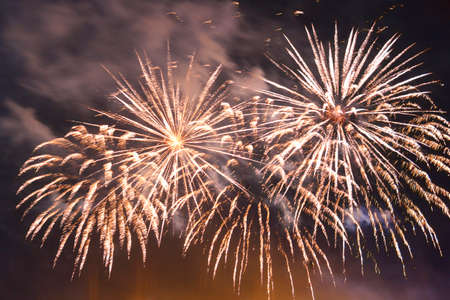 Bright fireworks on the dark night sky in the smoke. Horizontal photoの写真素材