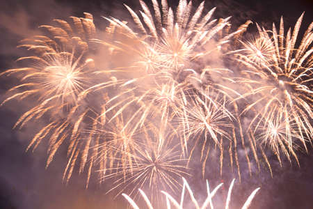Sparkling golden fireworks against the dark night sky in the smoke. Horizontal photoの写真素材