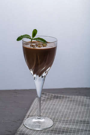 Chocolate cocktail with nuts and mint in a glass on a black background. Vertical photoの写真素材