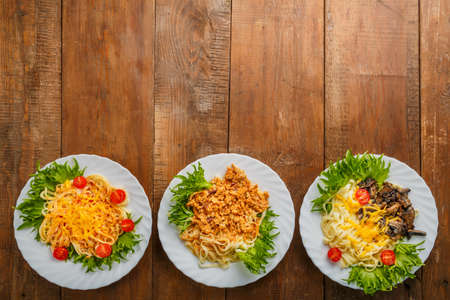 Three plates with different pasta on a wooden table. copy space. Horizontal photoの写真素材
