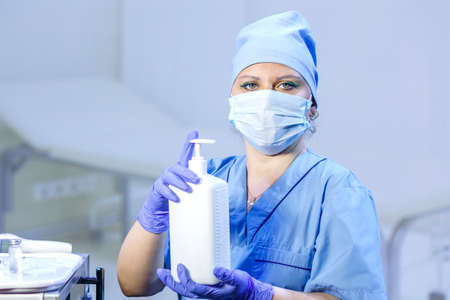 A doctor in medical gloves and a mask holds an antiseptic in his hands. Horizontal photoの写真素材