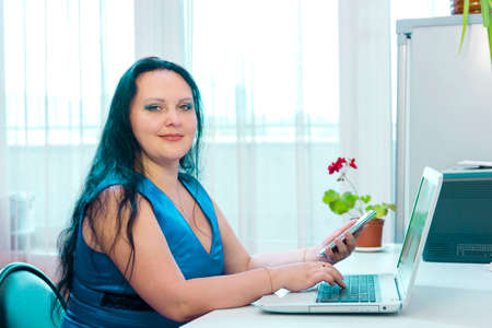 A brunette Jewish woman makes purchases on the Internet by paying with a bank card. Horizontal photoの写真素材