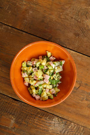 Okroshka in a clay bowl on a table on a wooden table.の写真素材