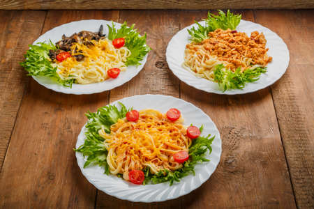 Three plates with different pasta on a wooden table. Horizontal photoの写真素材
