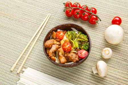 Udon with meat and vegetables in yakiniku sauce in a plate next to chopsticks and vegetables. Horizontal photoの写真素材
