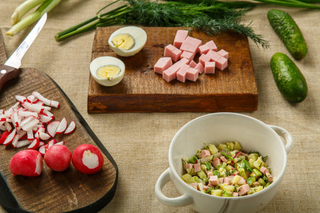 Okroshka in a tureen on the table on a tablecloth next to vegetables on boards. Horizontal photoの写真素材
