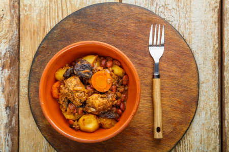 Jewish dish chelnt with meat on the table in a plate on a round stand. Horizontal photoの写真素材