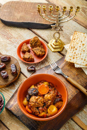 Jewish dish shut with meat on a wooden table near matzo and ingredients. Vertical photoの写真素材