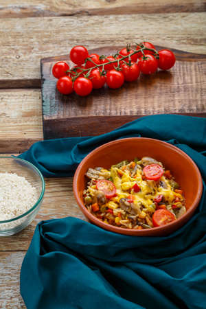 Risotto with mushrooms in a plate on a wooden background on a blue napkin and ingredients.の写真素材