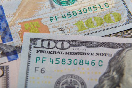 One hundred dollar bills are laid out on the table close-up.