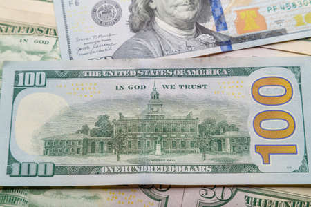 Fifty and one hundred dollar bills lie on a level surface in disarray.