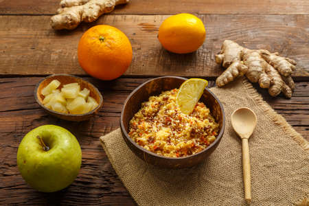Masfouf from couscous with dried fruits and nuts next to it on a napkin, a spoon on the table, fruits and ginger. horizontal photoの写真素材