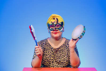 A Jewish woman in a headdress and carnival mask controls the noise on Purim while reading the scroll...