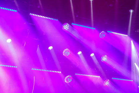Neon purple light from spotlights in vertical beams on the stage. horizontal photoの写真素材