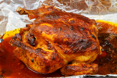 Whole baked chicken carcass stuffed with pears in soy sauce with a crispy crust on foil. horizontal photoの写真素材
