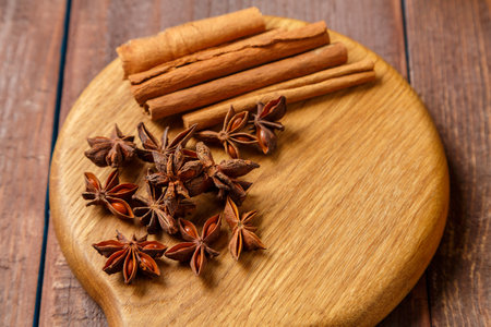 Cinnamon sticks, anise stars on a round wooden board.copy space Horizontal photo.の写真素材