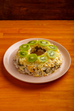 Salad with chicken and kiwi malachite bracelet on a beige plate on the table. vertical photoの写真素材