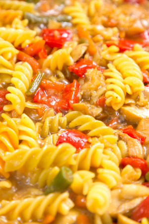 Pasta with vegetables and champignon mushrooms in sauce and spices close-up.の写真素材