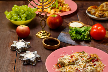 Shabbat set table with traditional food, fruits, burning candles and menorah. horizontal photoの写真素材
