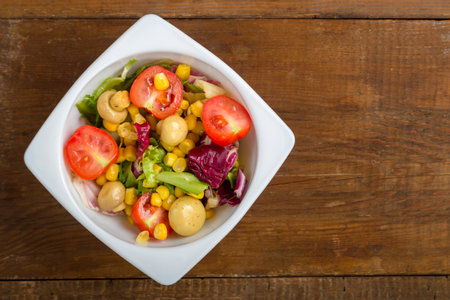 Vegetable salad with champignon corn and cherry tomato with avocado in a white plate. save a place. horizontal photoの写真素材