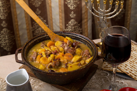 A laid table and a hot cholent for a meal and a menorah. horizontal photo.の写真素材