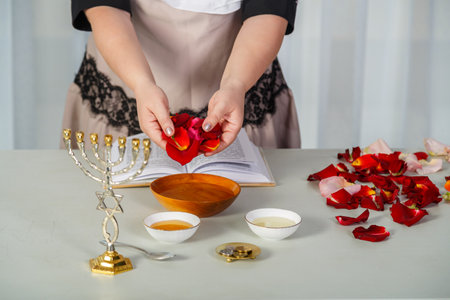 A Jewish woman reads a blessing on her husband's love before the wedding, rose petals and tegilim on the table. horizontal photo.の写真素材