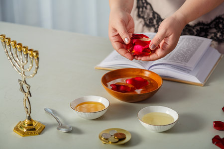A Jewish woman reads a blessing on her husband's love before the wedding, rose petals and tegilim on the table. horizontal photo.の写真素材