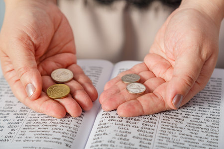 A Jewish woman reads a blessing on family wealth before the wedding of silver shekels in her hands and tegilim. horizontal photo.の写真素材