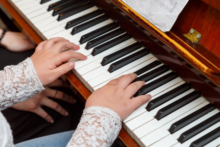 The child learns to play the piano under the guidance of a teacher. horizontal photoの写真素材