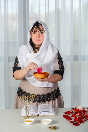 A Jewish woman performs superstitious rituals before her wedding with rose petals to be the most beautiful for her husband. vertical photoの写真素材