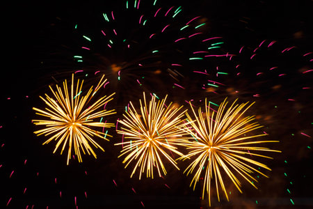 Golden sparks of fireworks bright shining on the black night sky.. Horizontal photo.の写真素材