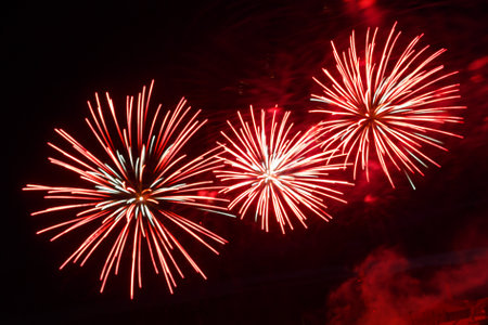 Burgundy pink firework sparks bright shining on the black night sky. horizontal photoの写真素材