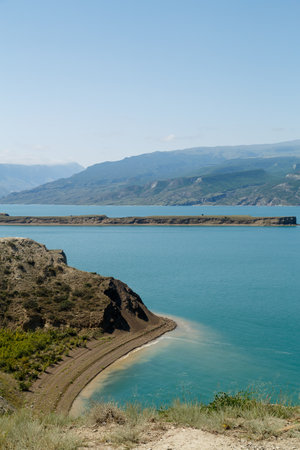 Mountain lake against the backdrop of mountains with lustrous water on a sunny day. Vertical photoの写真素材