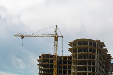 Construction of a multi-storey residential building in a new area with a crane. Horizontal photo.